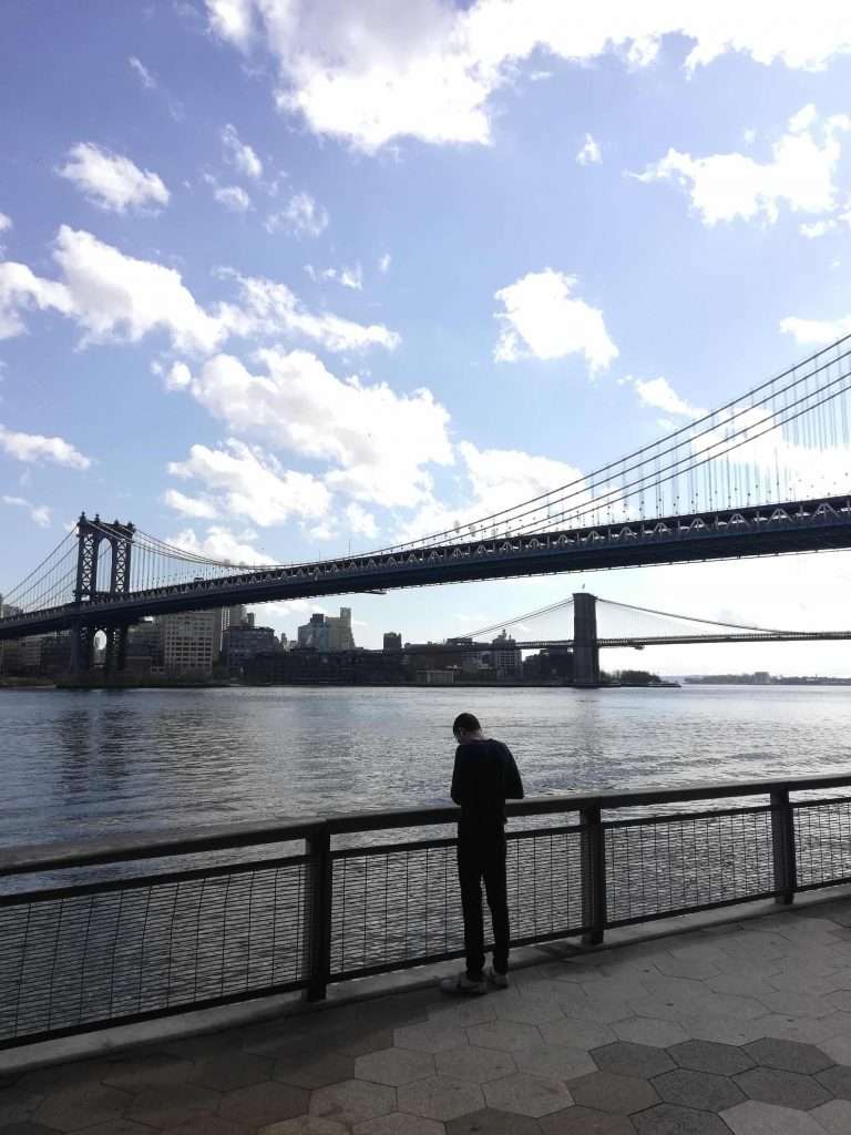 Man standing alone by Manhattan Bridge NYC