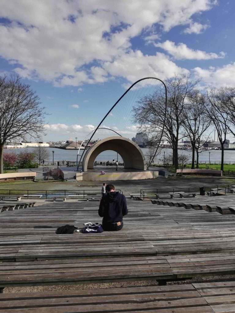 Man sitting at East River park stage bench