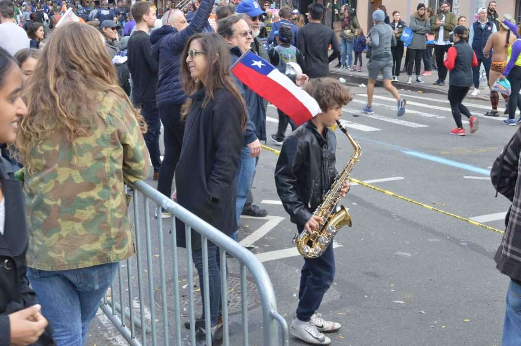Kid playing saxophone during NYC marathon